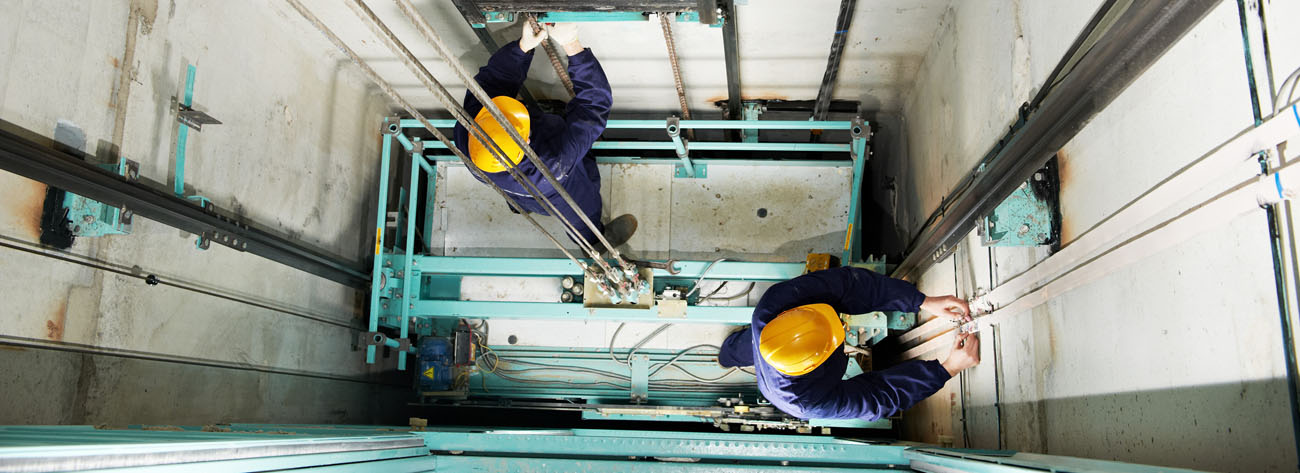 Técnicos da JND Elevadores realizando manutenção no poço do elevador